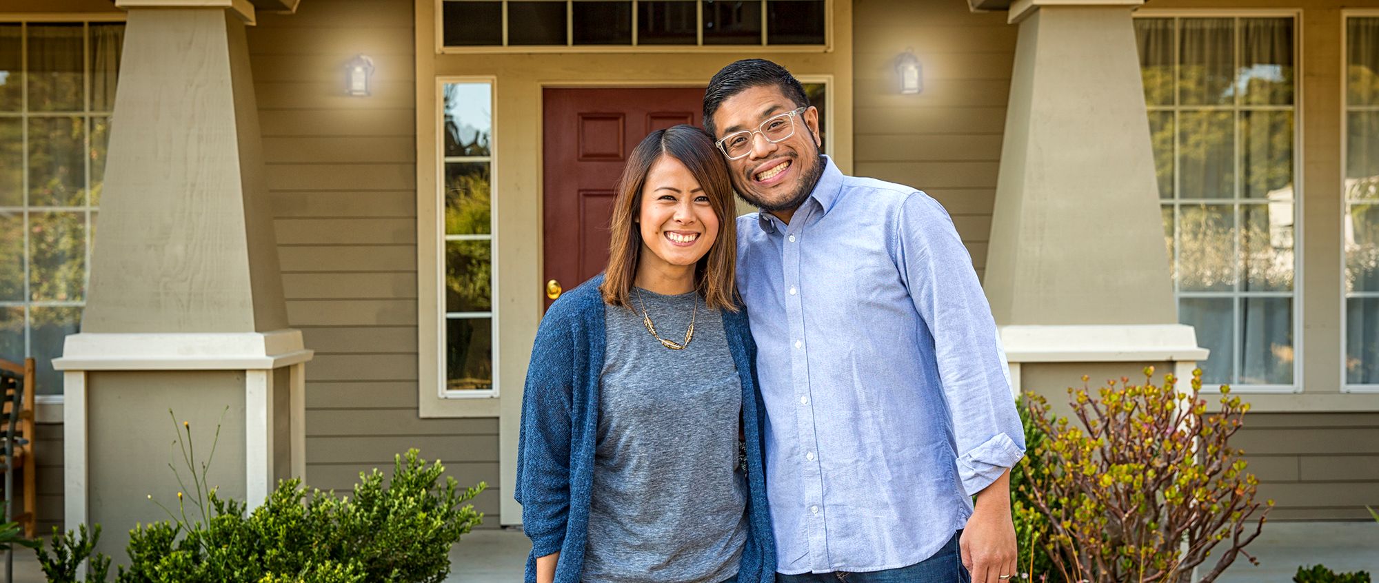 couple in front of their new home with down payment assistance
