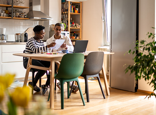 couple working on savings habits in kitchen