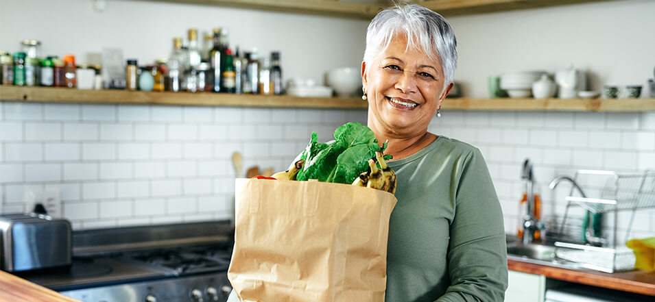 woman with a grocery bag of healthy food