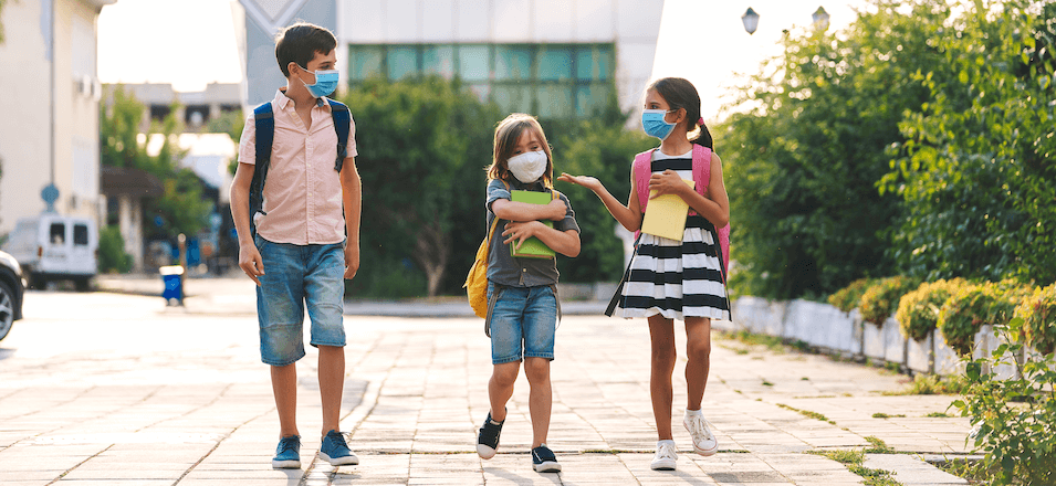 Children with school supplies in masks