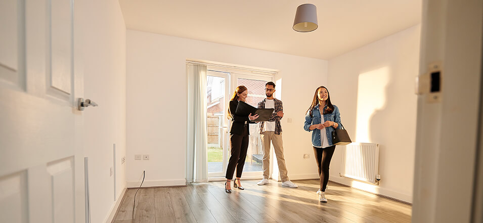 couple walking into their new home with realtor