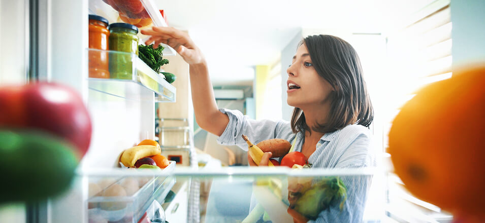 Woman reaching in fridge