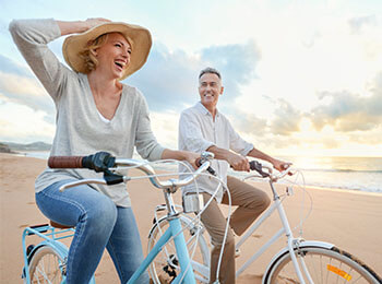 A couple riding bikes on the beach
