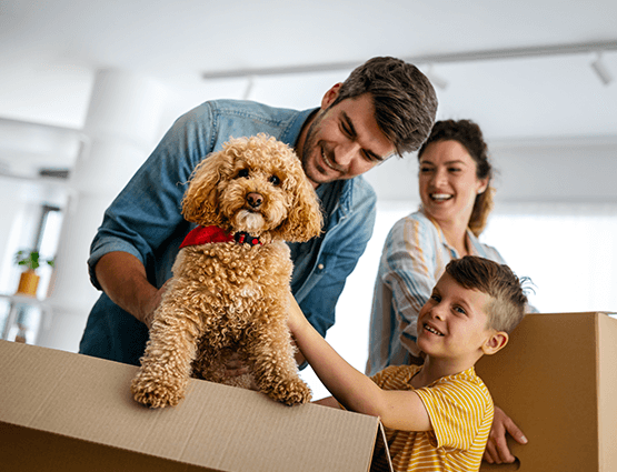 family and dog unpacking boxes