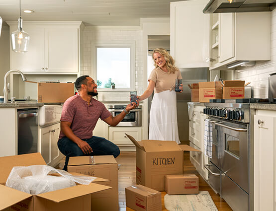 couple unpacking boxes in new home