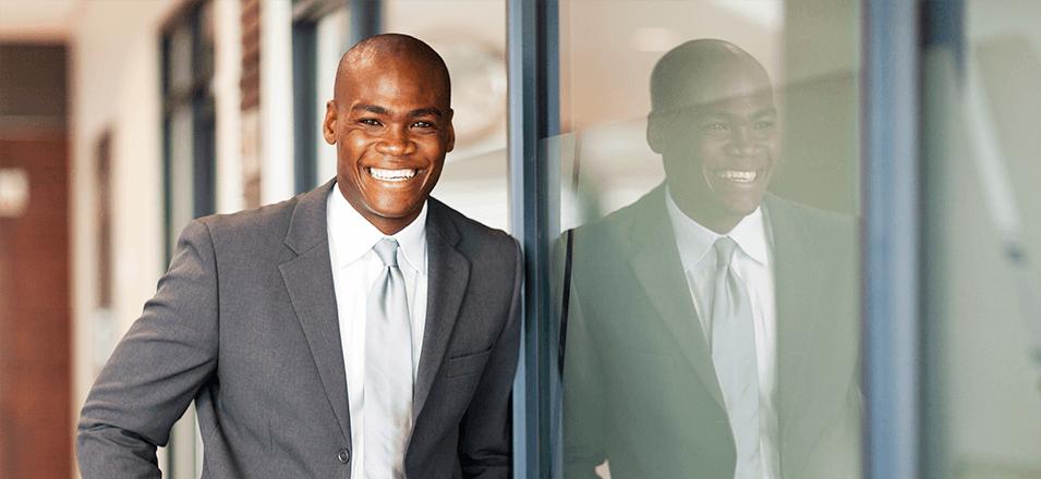 Smiling business man standing against wall