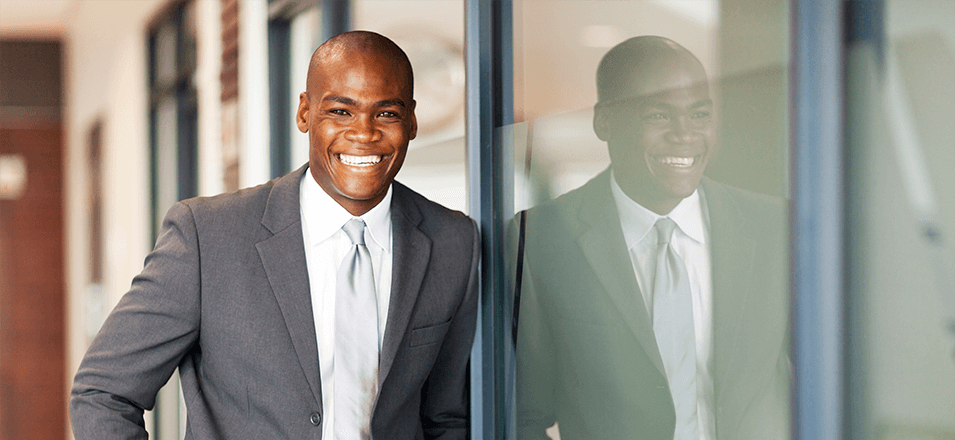 Smiling business man standing against wall 