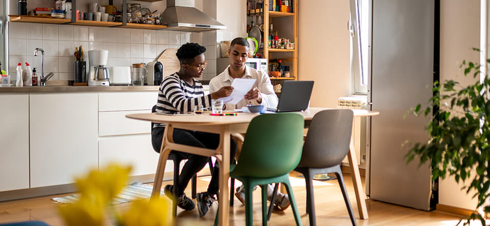 black couple working on savings habits in kitchen