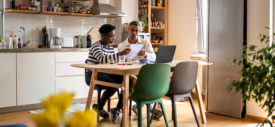 couple working on savings habits in kitchen