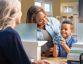 happy kid opening a savings account with his mom at United Community