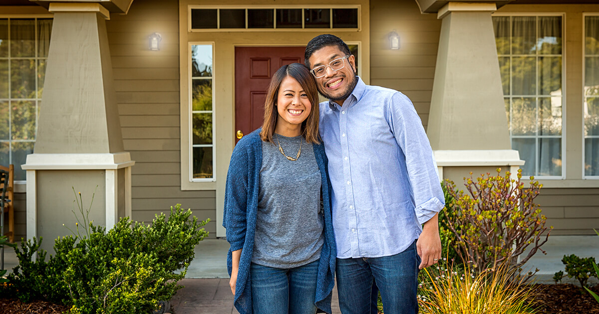 couple in front of their new home with down payment assistance