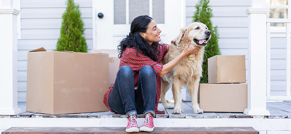 woman and dog in front of home