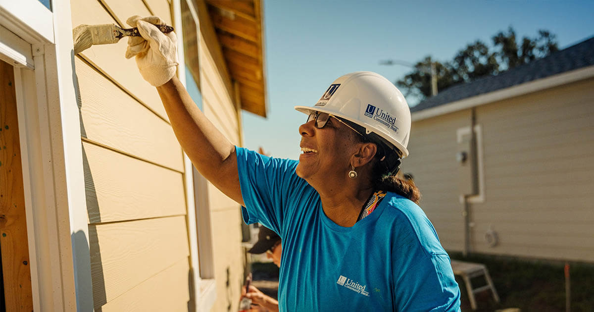 lady painting at a Habitat for Humanity build site