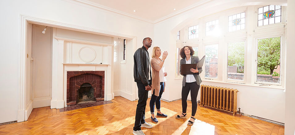 Female real estate agent showing couple a house