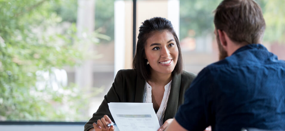 Man and woman sitting at desk with paper