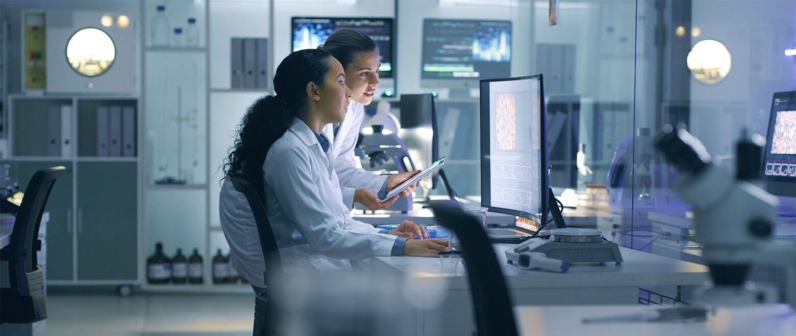 Female Doctors in Lab with Microscope