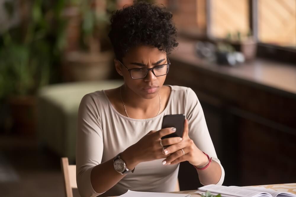 concerned woman looking at mobile device 