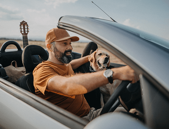 man driving his car with dog