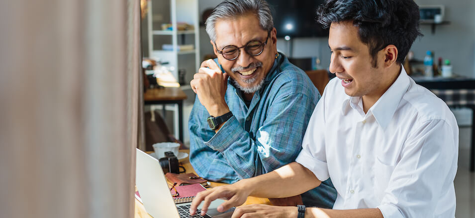 Man and his father at table with laptop