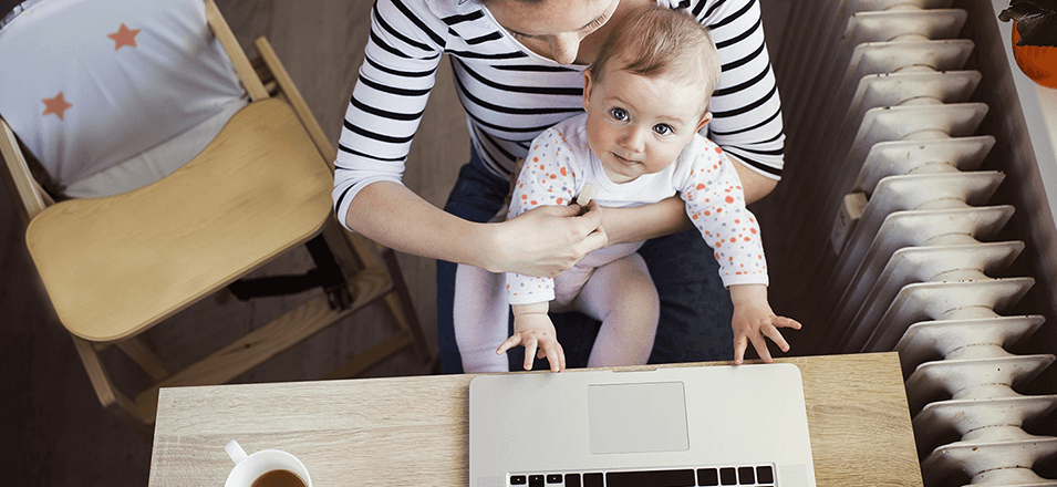 baby sitting on woman's lap at laptop computer