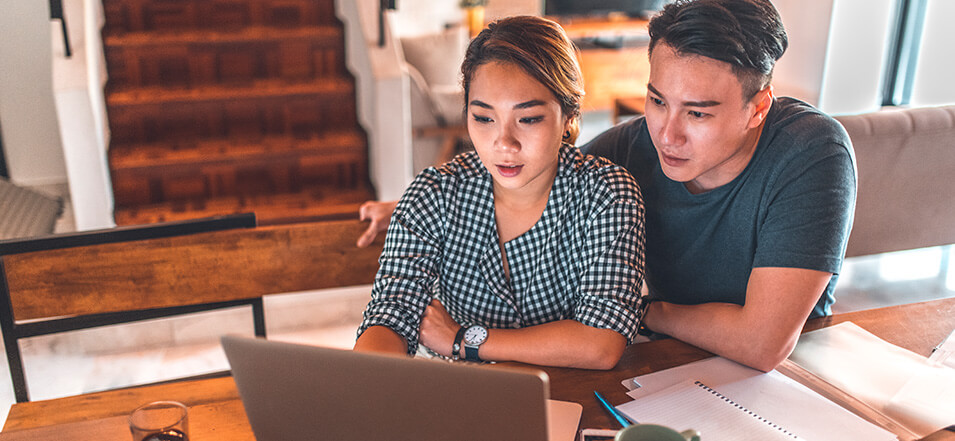 young asian couple looking into finances on laptop