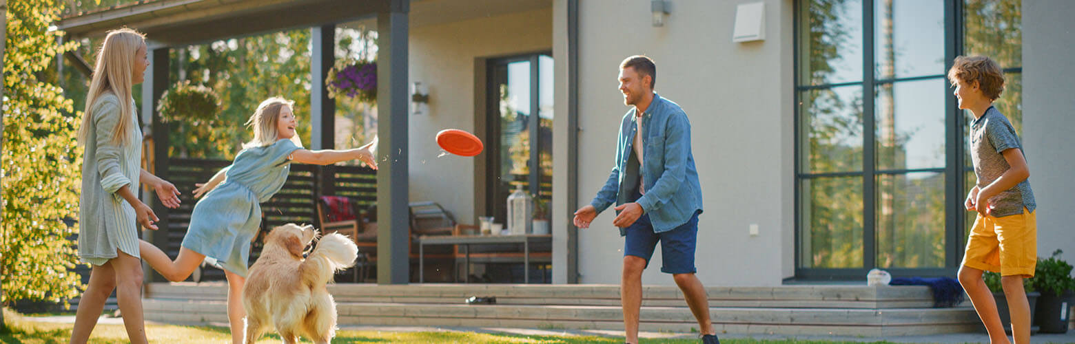 family playing in front yard of home