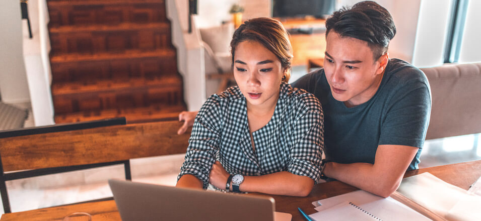 Couple using laptop at home